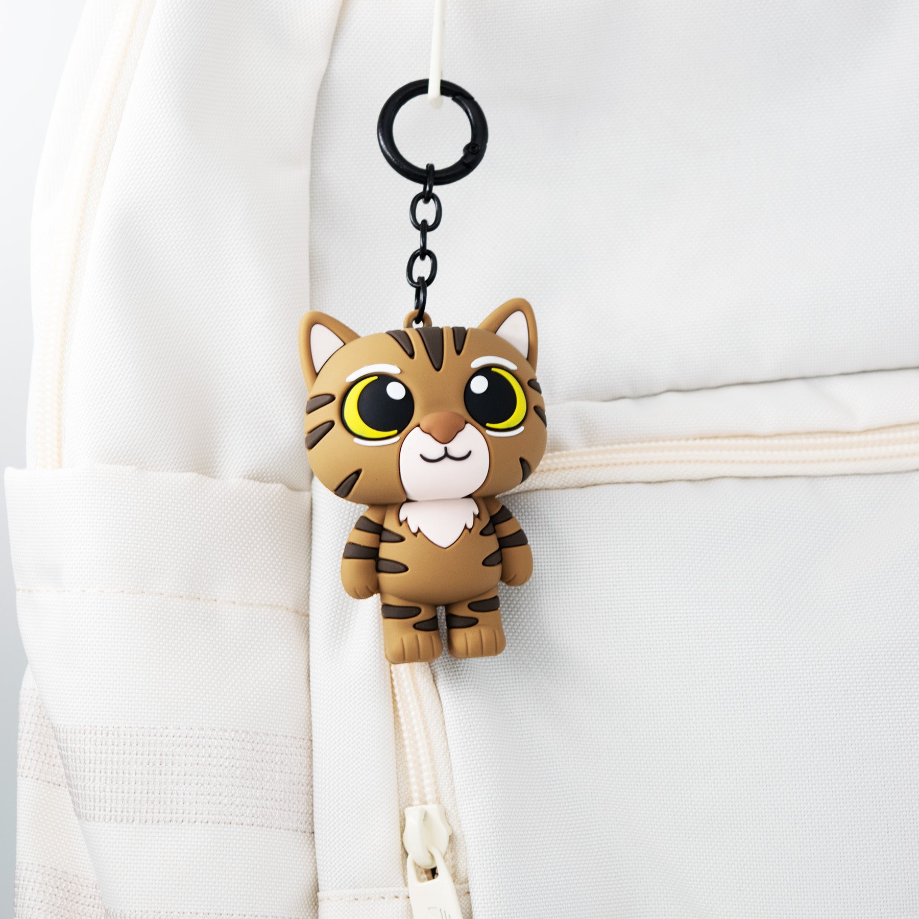 Cat-shaped bag charm keychain attached to a bag strap
