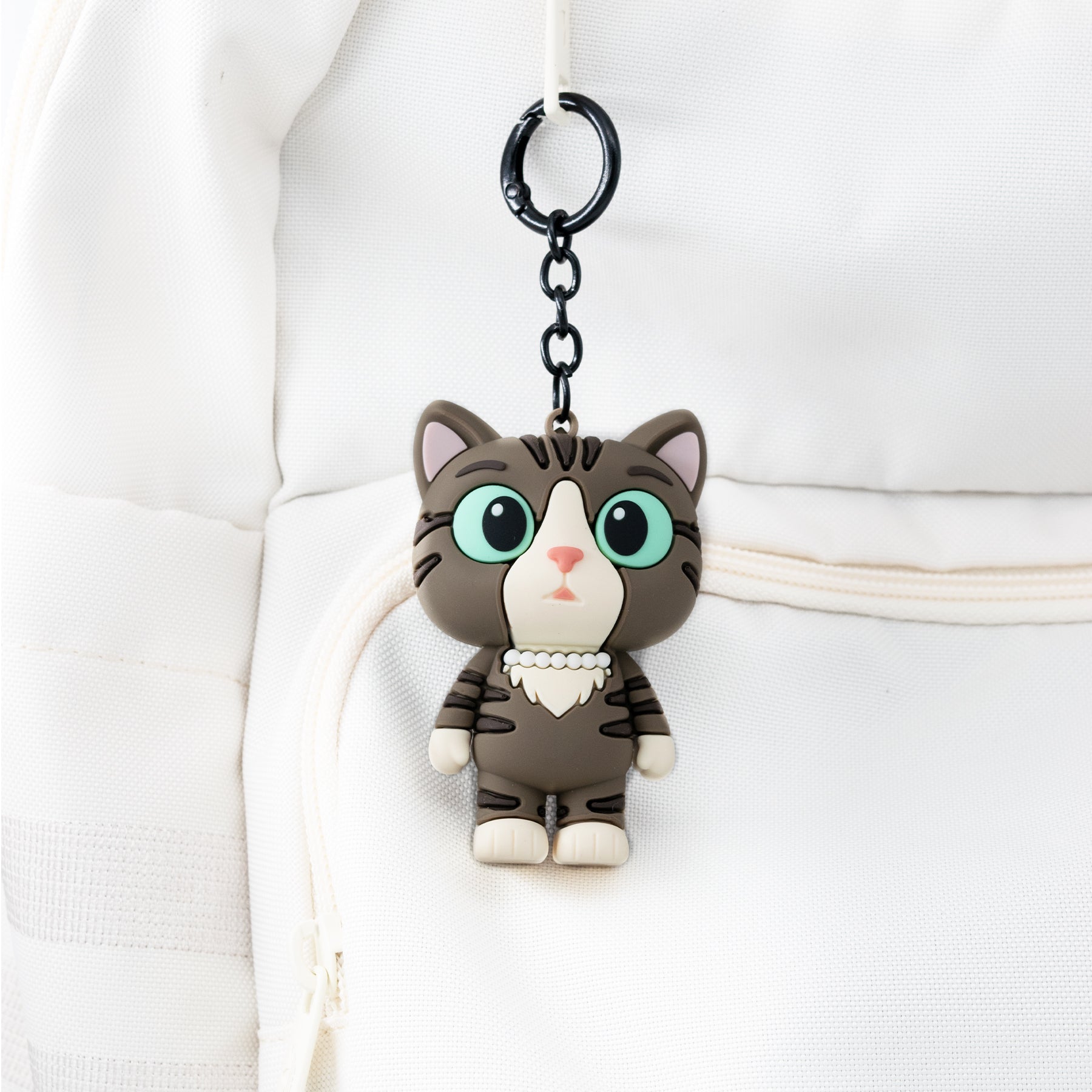 Cat-shaped bag charm keychain on a backpack